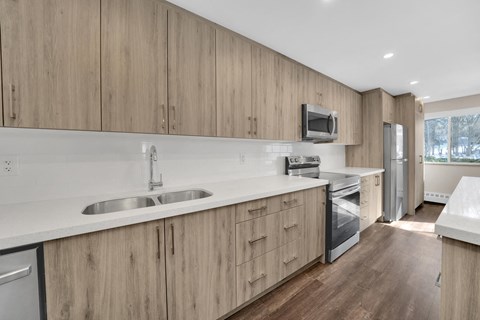 a kitchen with white counter tops and wooden cabinets