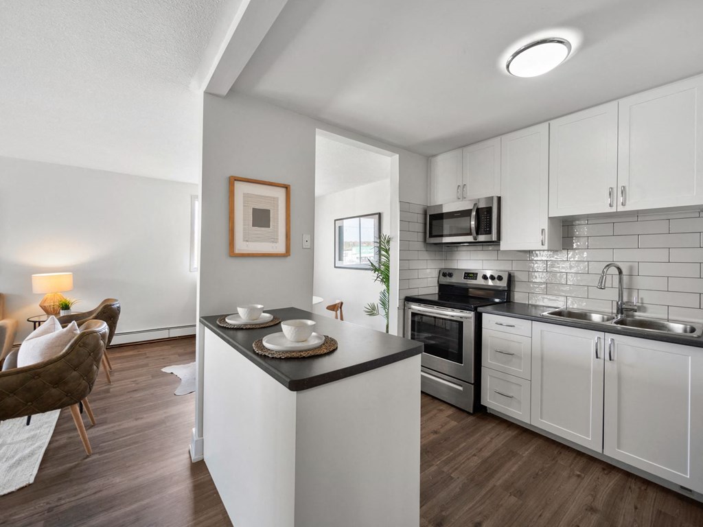 a kitchen with white cabinets and a black counter top