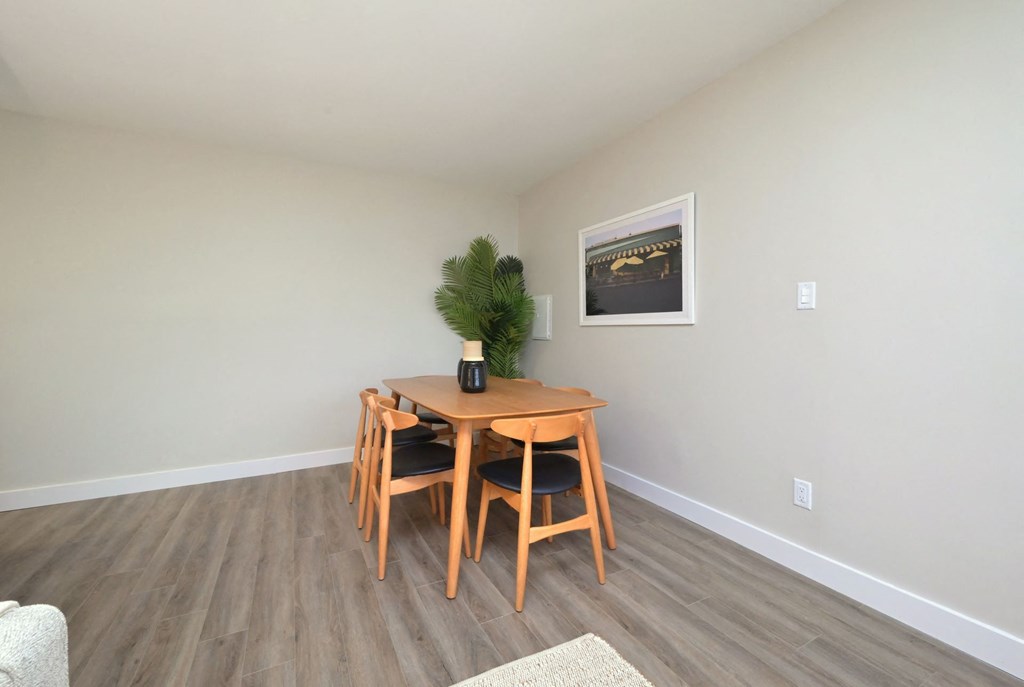 a dining area with a wooden table and four chairs