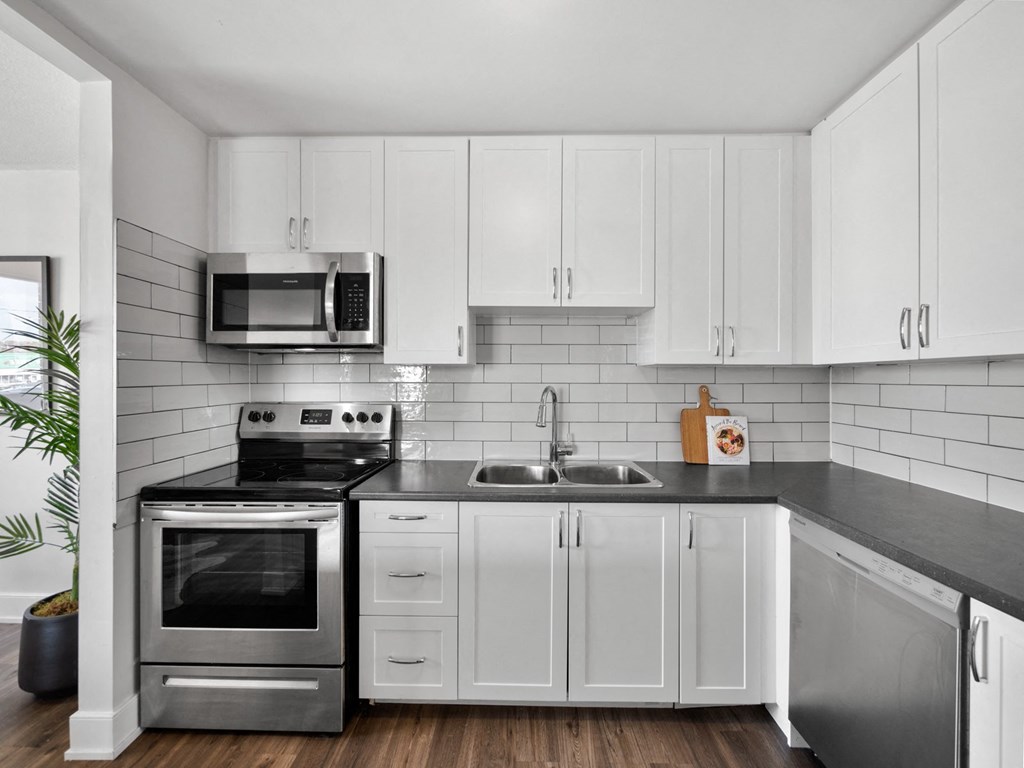 a kitchen with white cabinets and stainless steel appliances