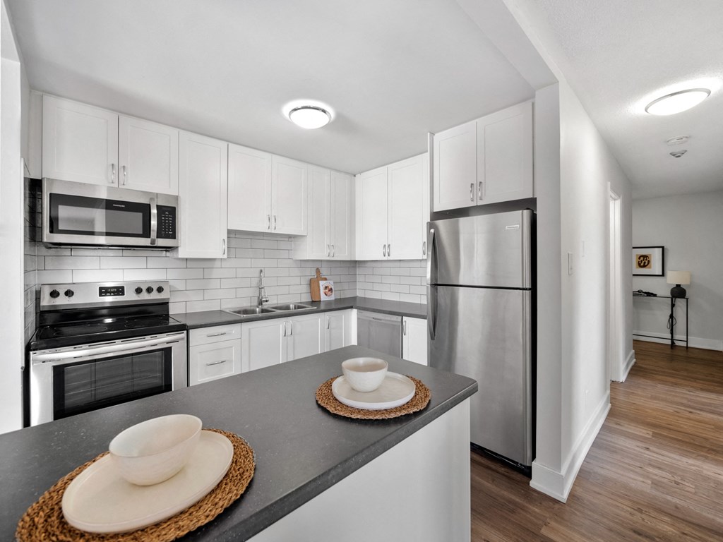 a kitchen with white cabinets and stainless steel appliances