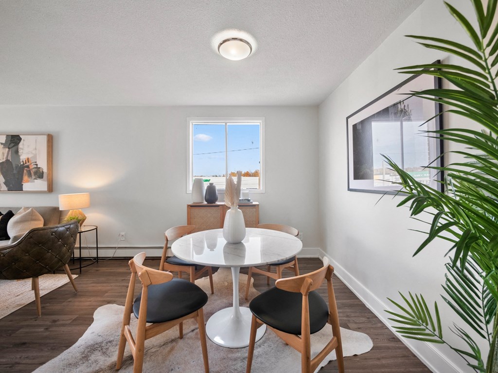 a dining room with a white table and four chairs