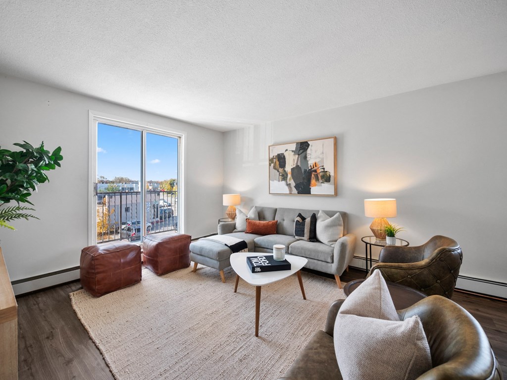 a living room with a large window and hardwood floors