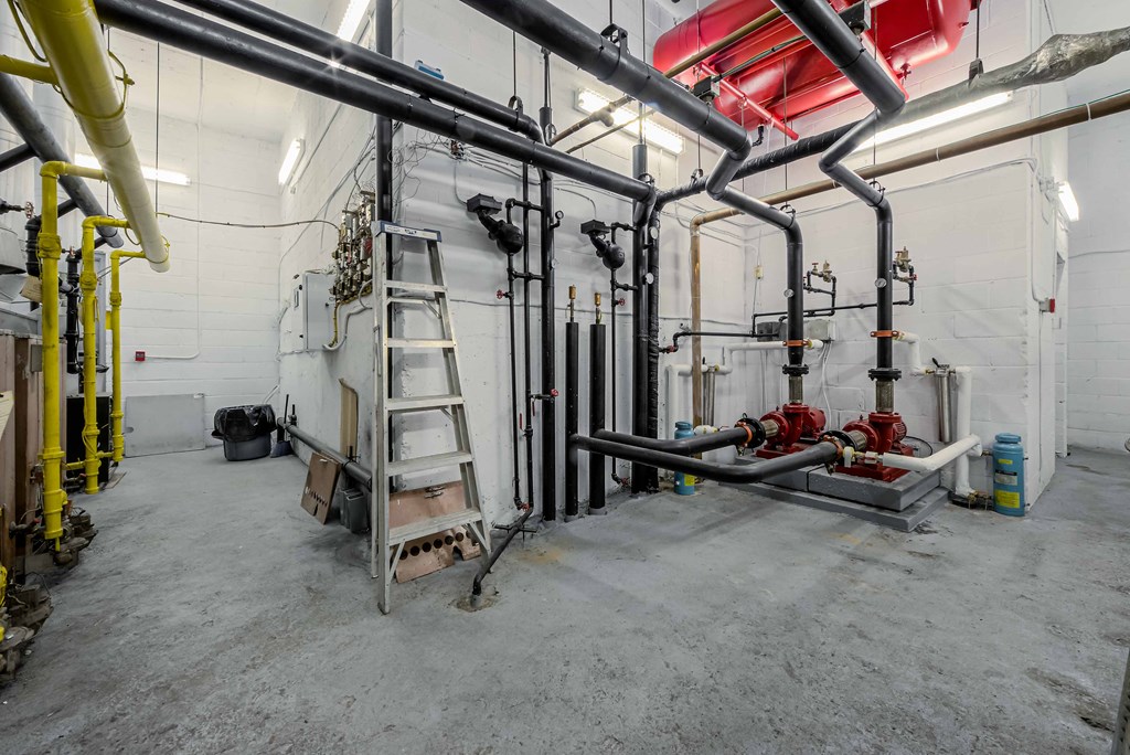 a large room with pipes and a ladder