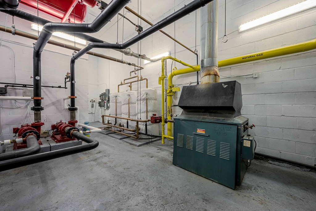 a large boiler room with pipes and a furnace