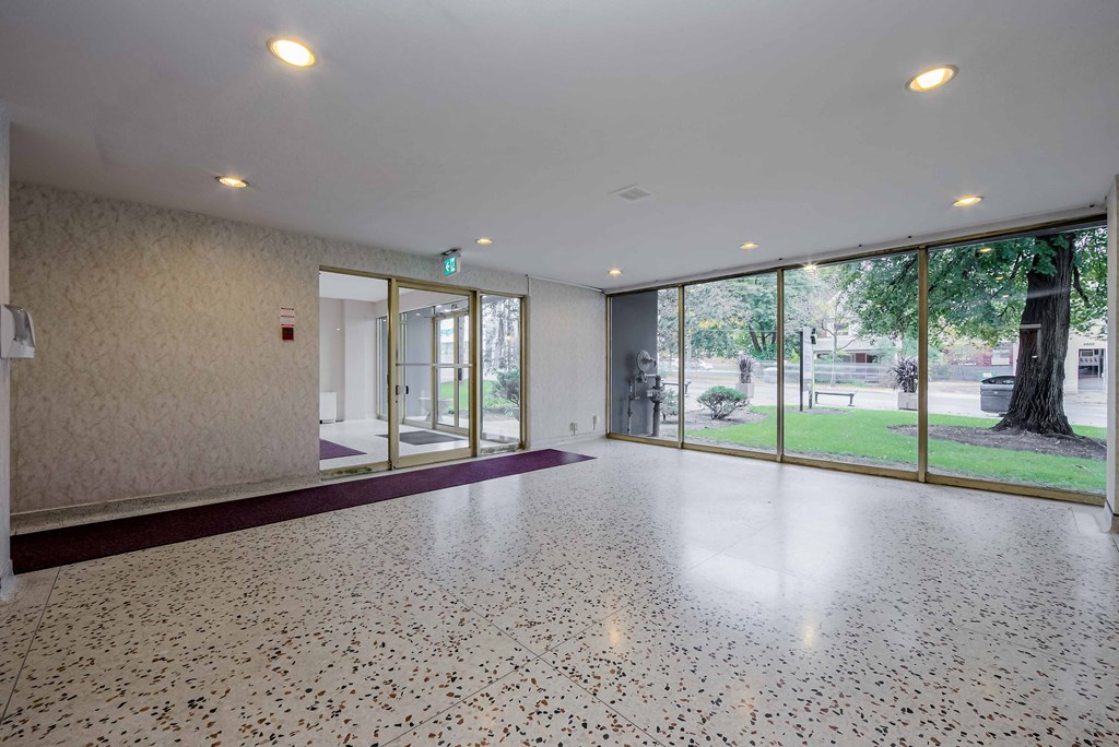 a large room with a large window and a purple rug on the floor