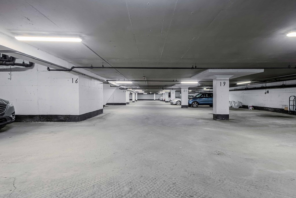 an empty parking garage with white walls and white pillars