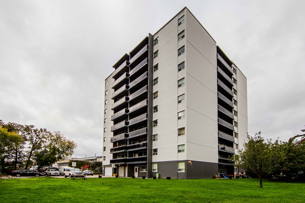 a large white building with a green lawn in front of it