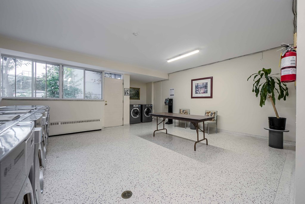 a large room with a ping pong table and washer and dryer