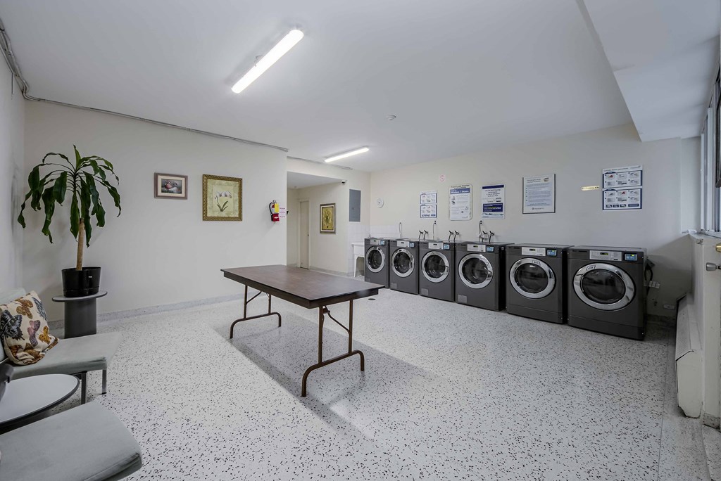 a laundromat with a table and a row of washing machines