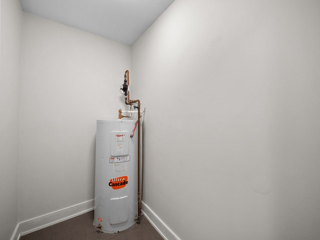 a room with a water heater and a white wall