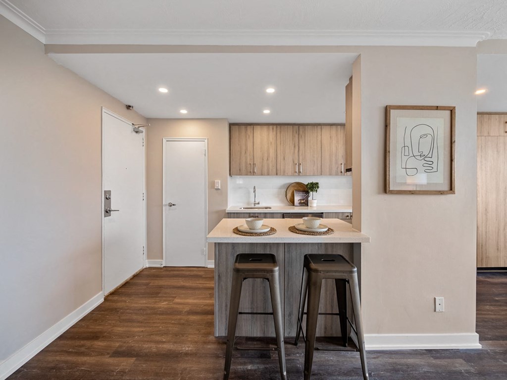 a kitchen with an island with two stools in front of it