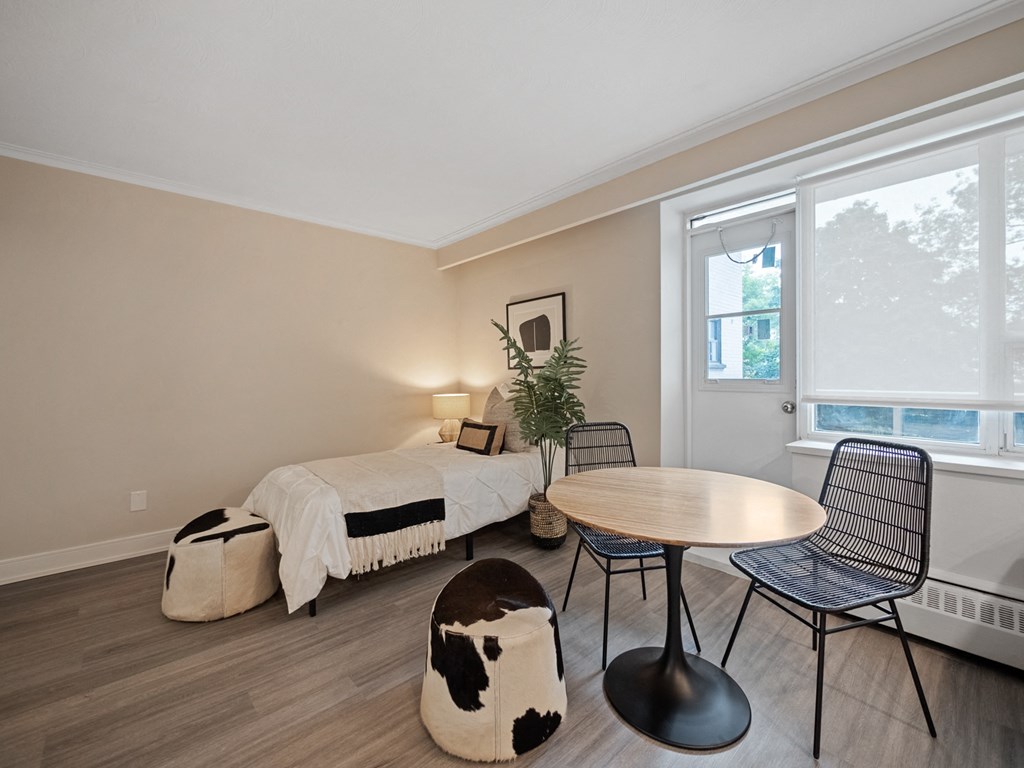 a bedroom with a bed and a table and chairs