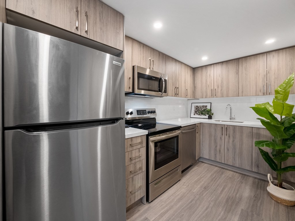 a kitchen with wooden cabinets and stainless steel appliances