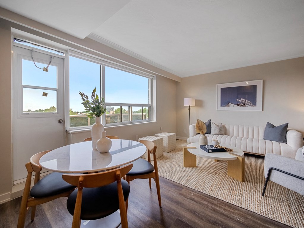 a living room with a white couch and a table with a vase on top of it