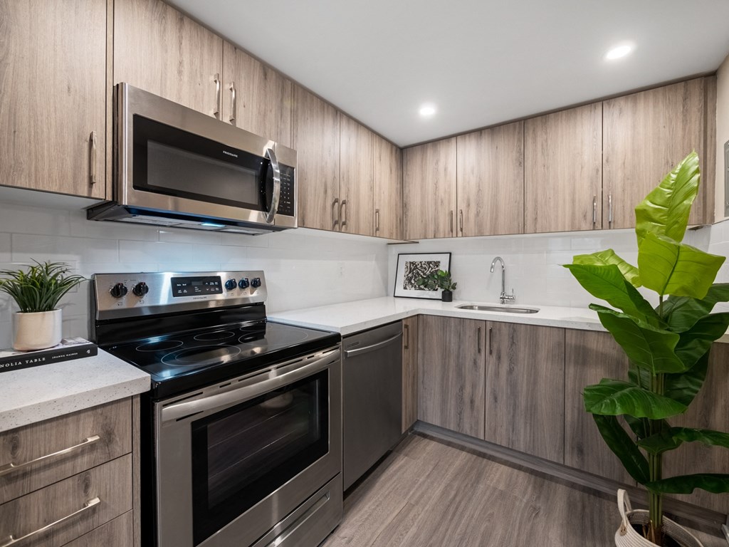 a kitchen with wood cabinets and stainless steel appliances