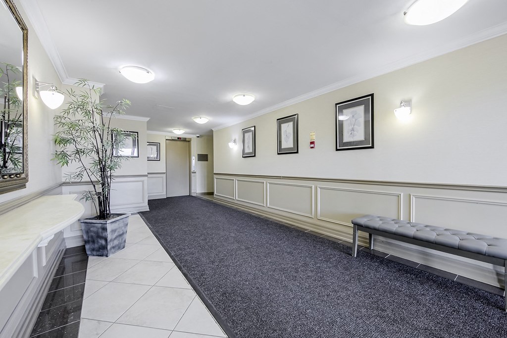 a long hallway with a bench and a potted plant
