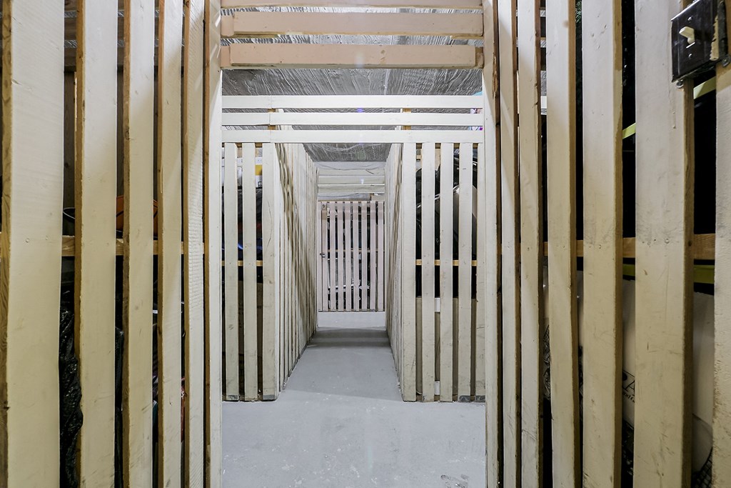 a view down a long corridor with wooden beams on each side of the corridor