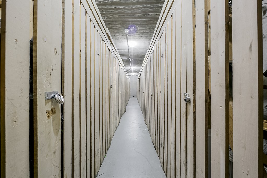 a row of empty shipping containers in a room with a light on the ceiling