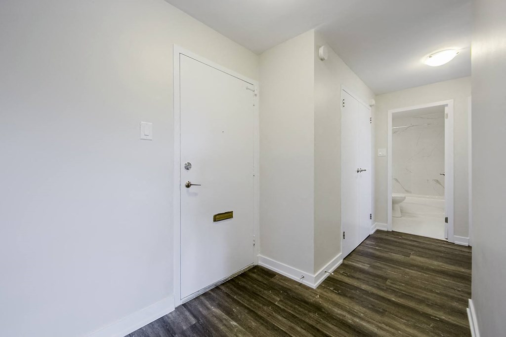 a bedroom with white walls and a wooden floor