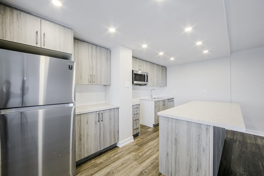 a kitchen with white cabinets and stainless steel appliances