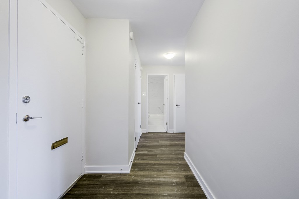 a bedroom with a medium hardwood floor and white walls