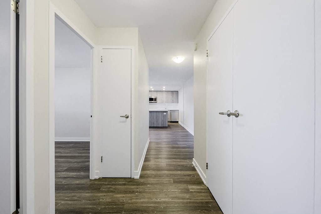 a bedroom with white walls and a wooden floor
