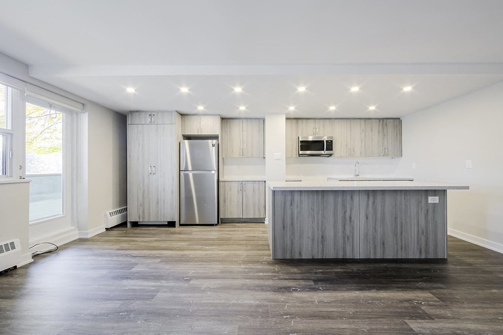a kitchen with a large island and stainless steel appliances