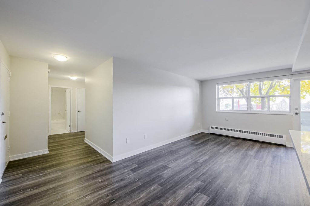 a bedroom with hardwood floors and white walls