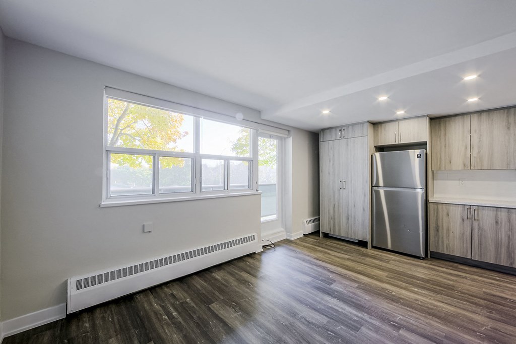 a bedroom with hardwood floors and white walls