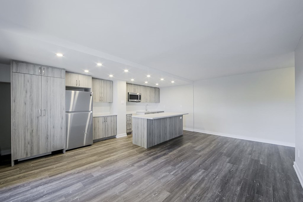 a kitchen with white walls and a wooden floor