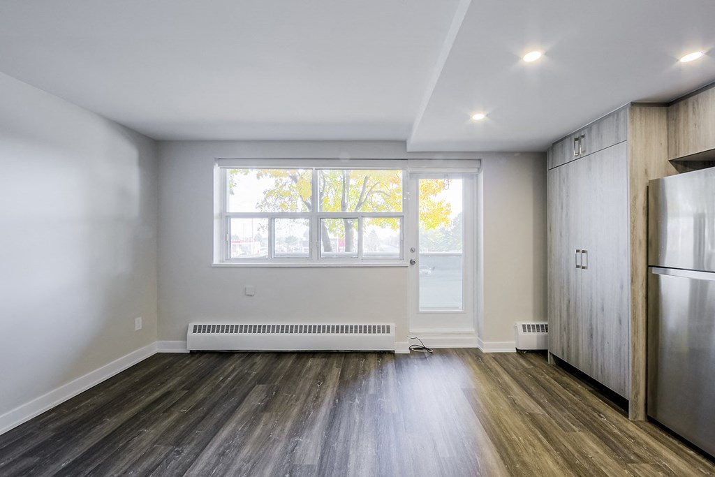 a bedroom with hardwood floors and white walls