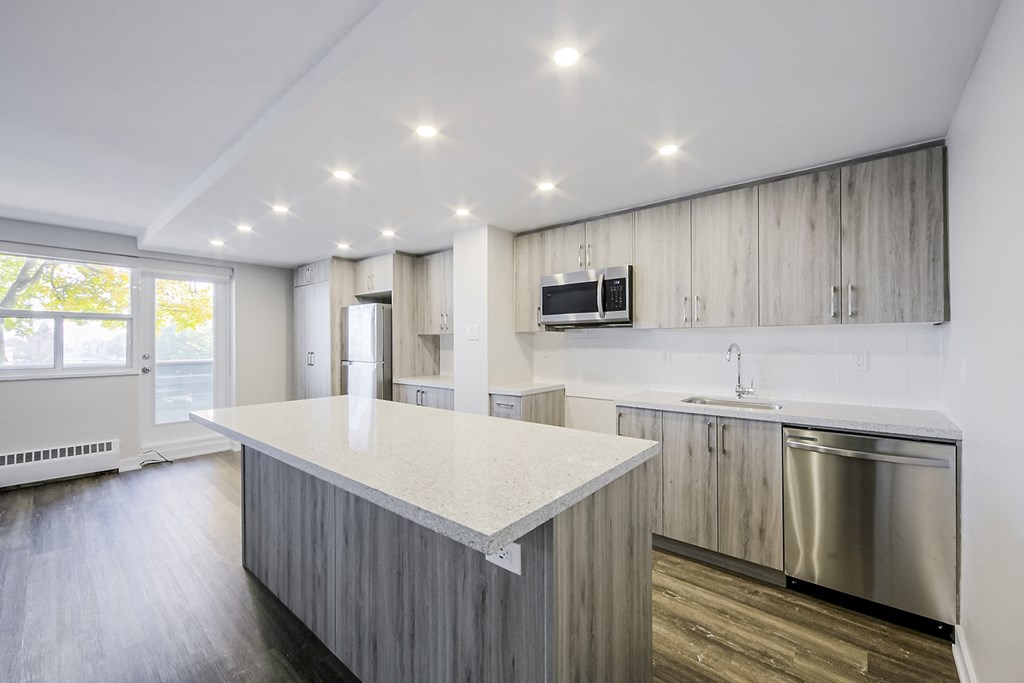 a kitchen with a large island and stainless steel appliances
