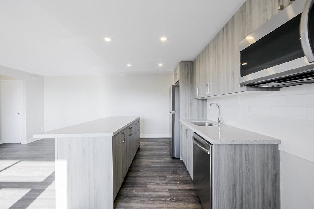 a kitchen with white walls and a wooden floor