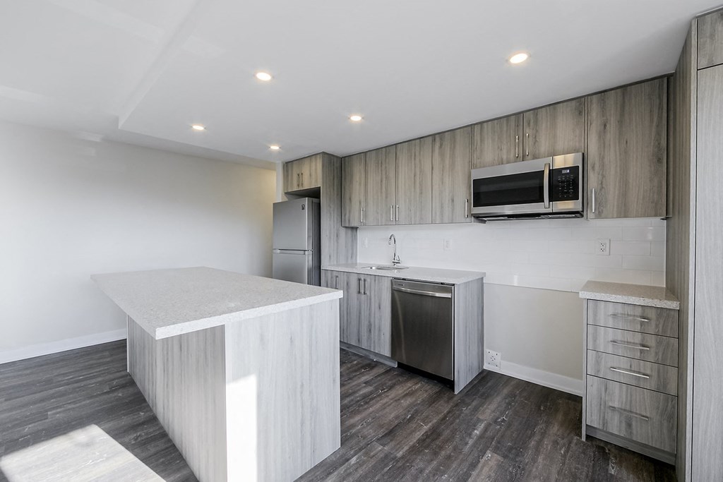 a kitchen with a large island and stainless steel appliances