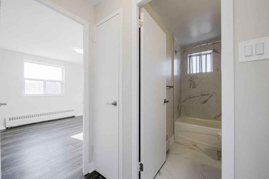 a bedroom with a large window and a door that leads to a bathroom