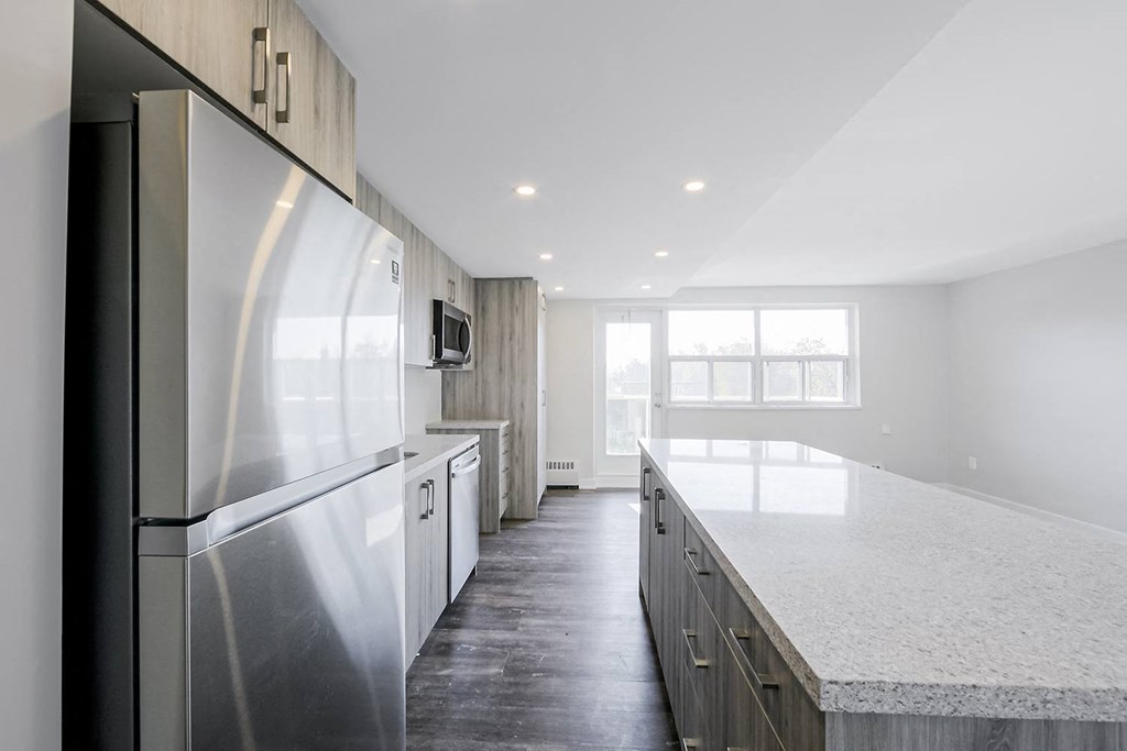 a kitchen with a large island and stainless steel appliances