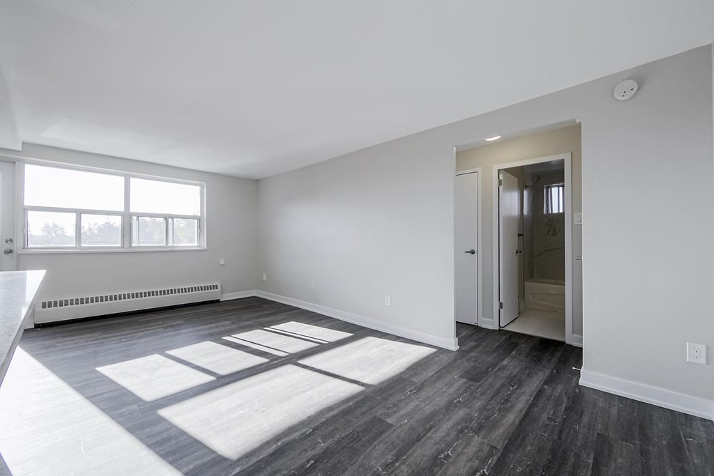 a bedroom with hardwood floors and white walls