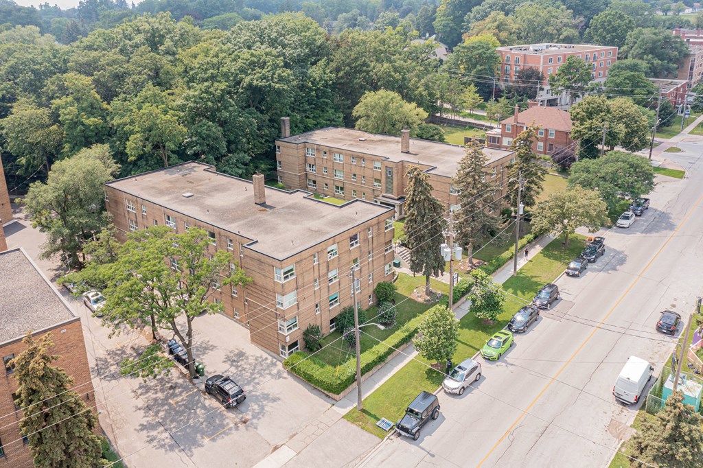 an aerial view of a brick building with cars parked on the side of the road