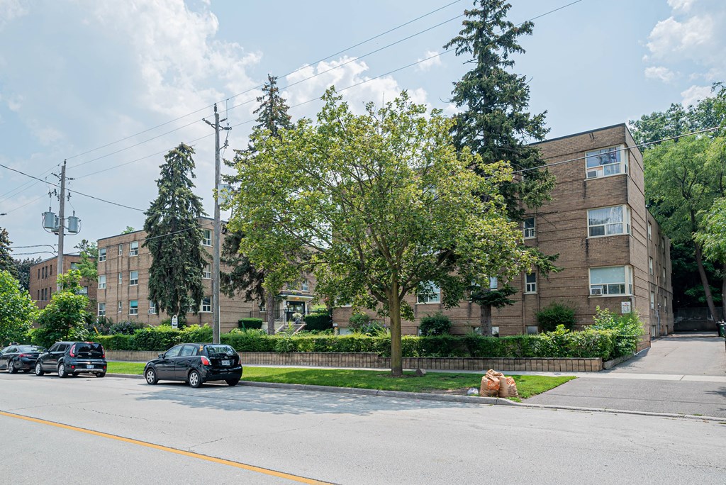 a large brick apartment building with cars parked in front of it