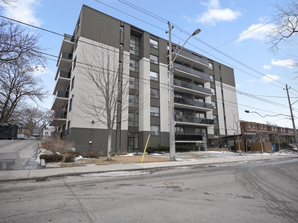 an image of a grey and white apartment building with a street light in front of it