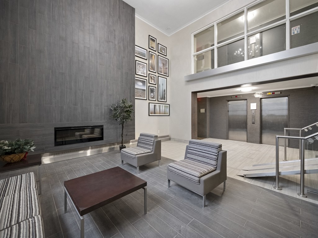 a seating area with two chairs and a coffee table in the lobby of a building