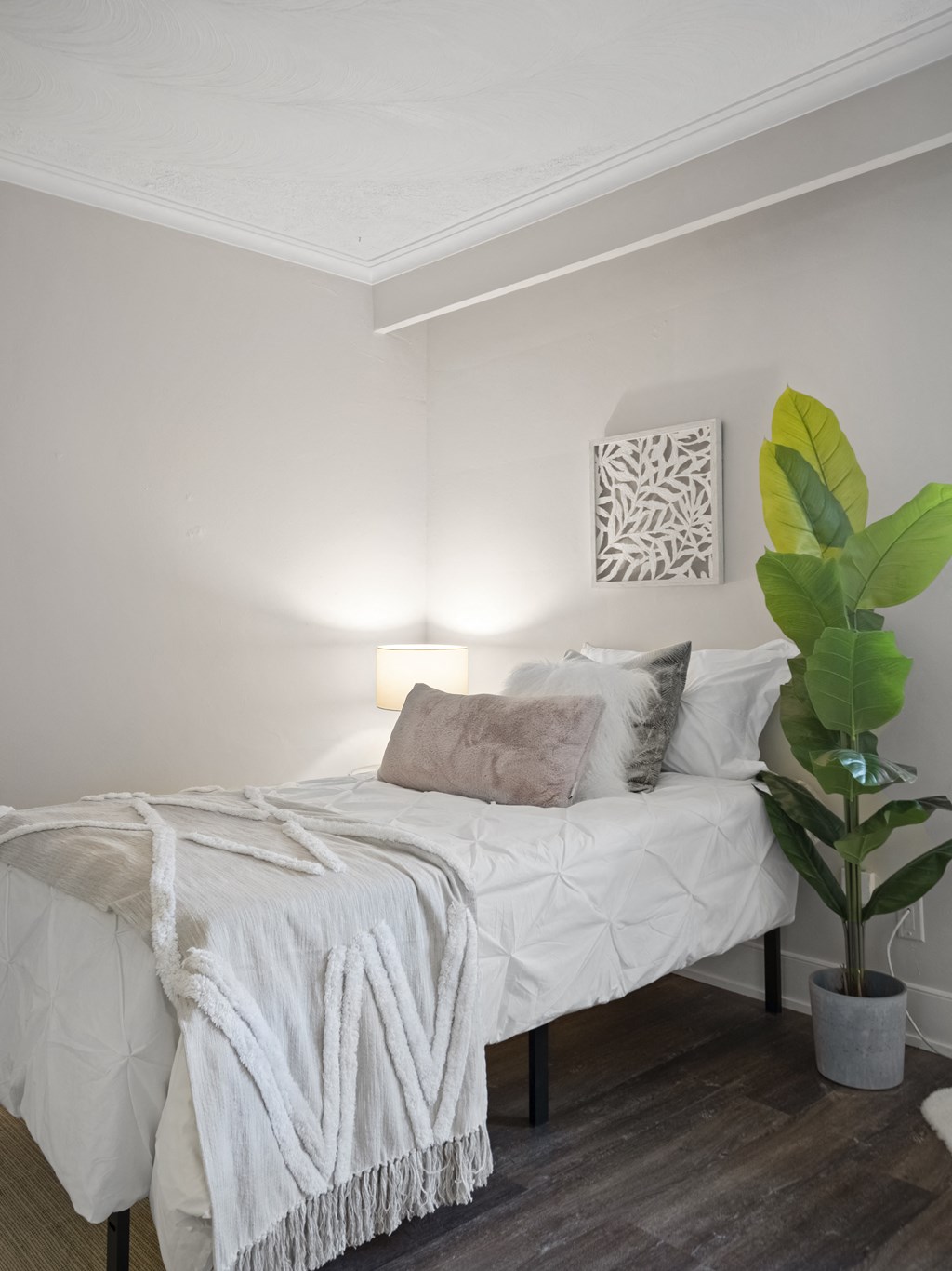 a bedroom with a bed and a plant