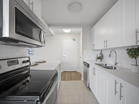 a kitchen with white cabinets and stainless steel appliances