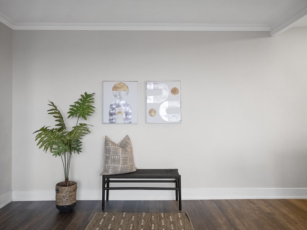 a seating area with a plant and artwork on the wall