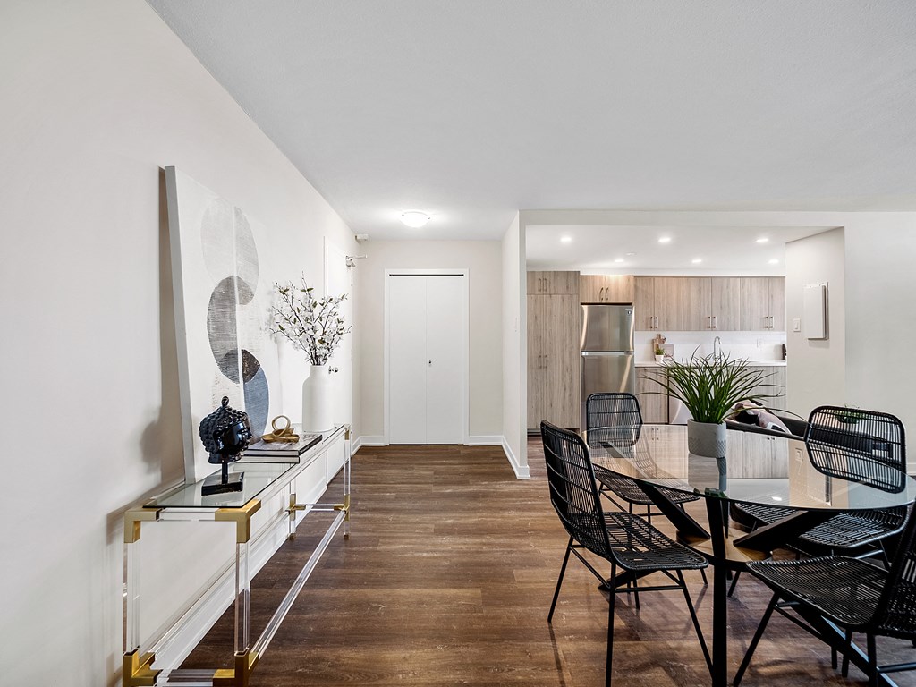 a dining area with a glass table and black chairs