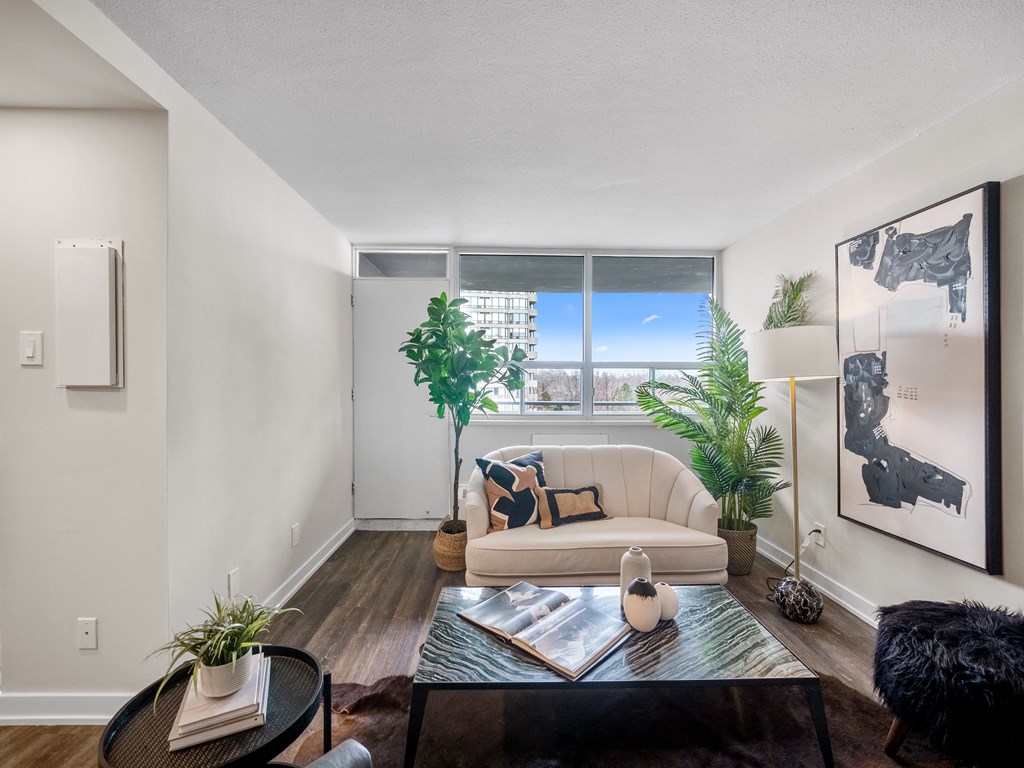 a living room with white walls and a large window