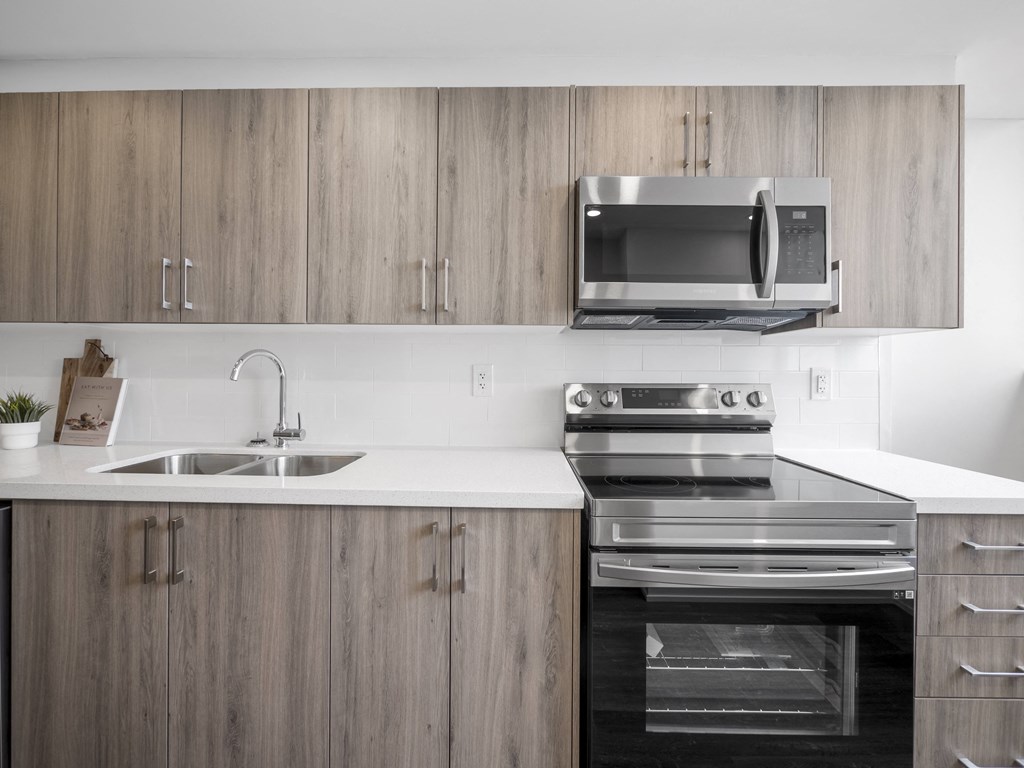 a kitchen with a stove top oven next to a sink and a microwave