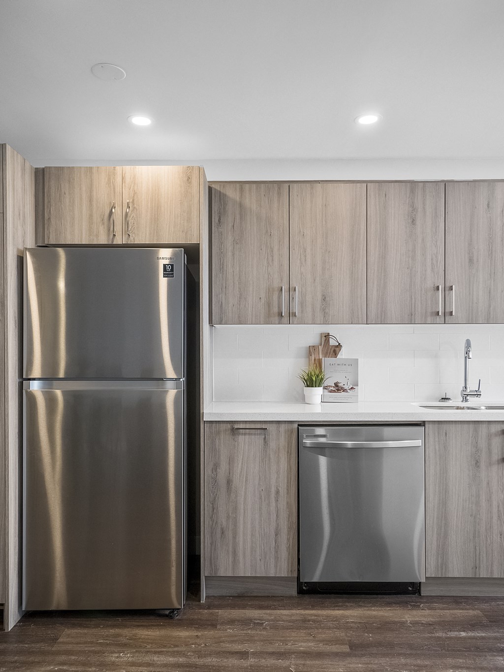 a kitchen with wooden cabinets and a stainless steel refrigerator