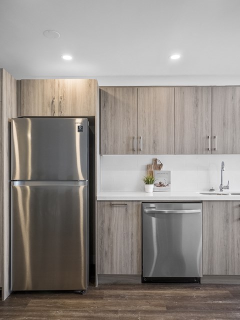 a kitchen with a stainless steel refrigerator and white counter tops